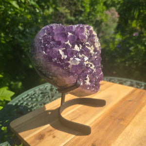 Amethyst Druse Amethyst Geode in Herzform mit Metallsockel 22x20x12cm - NR-6 auf einem Holzuntergrund im Freien
