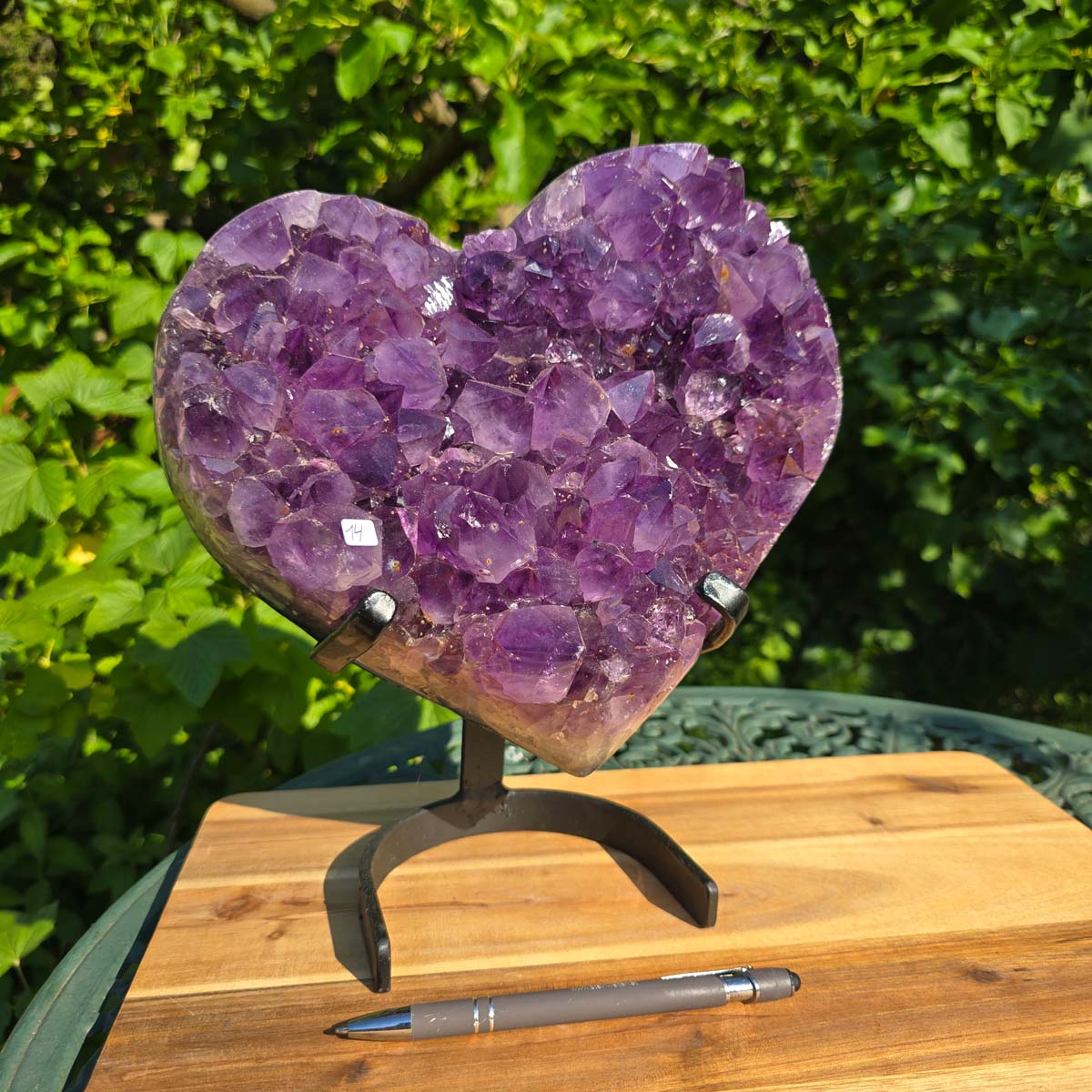 Amethyst Druse Amethyst Geode in Herzform mit Metallsockel 28x24x12cm - NR-14 auf einem Tisch mit Stift
