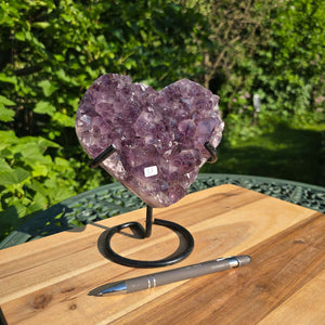 Amethyst Druse Amethyst Geode in Herzform mit Metallsockel 18x15x10cm - NR-37 auf Holzfläche mit Stift