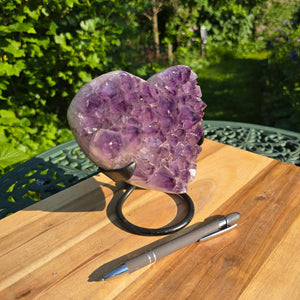 Amethyst Druse Amethyst Geode in Herzform mit Metallsockel 15x14x12cm - NR-40 auf Tisch mit Stift