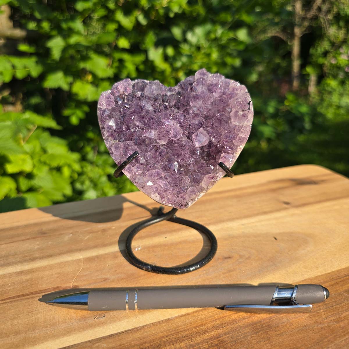 Amethyst Druse Amethyst Geode in Herzform mit Metallsockel 12x9x8cm - NR-49 auf Holzuntergrund mit Stift.