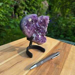 Amethyst Druse Amethyst Geode in Herzform mit Metallsockel 13x11x7cm - NR-51 auf einem Holzuntergrund.