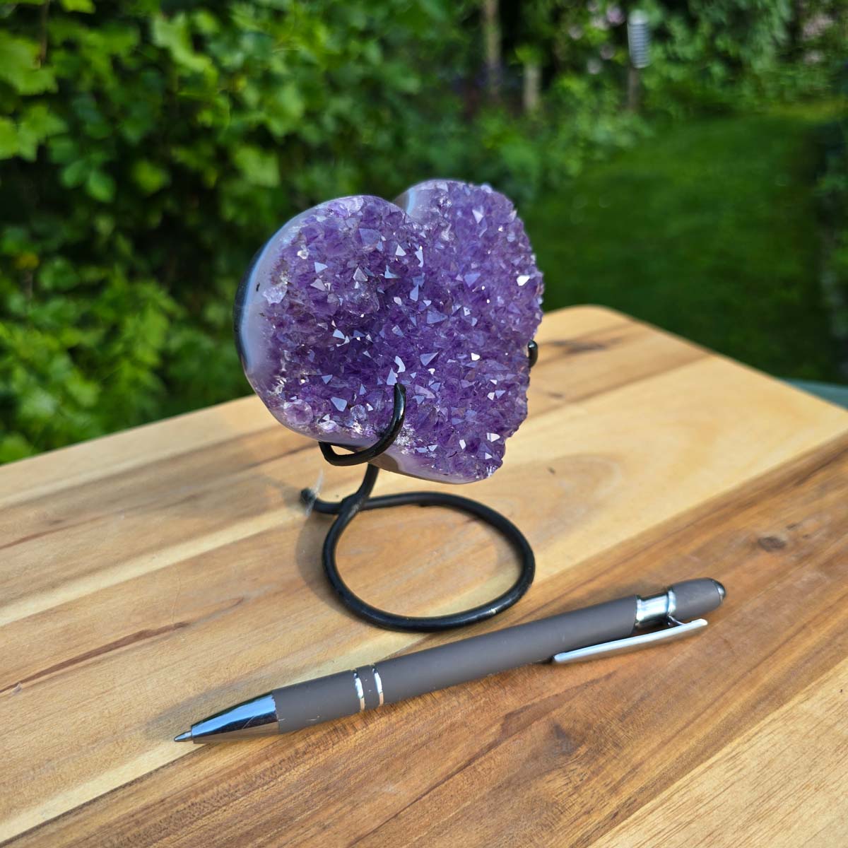Amethyst Druse Amethyst Geode in Herzform mit Metallsockel 12x10x9cm - NR-52 auf Holztisch mit Stift