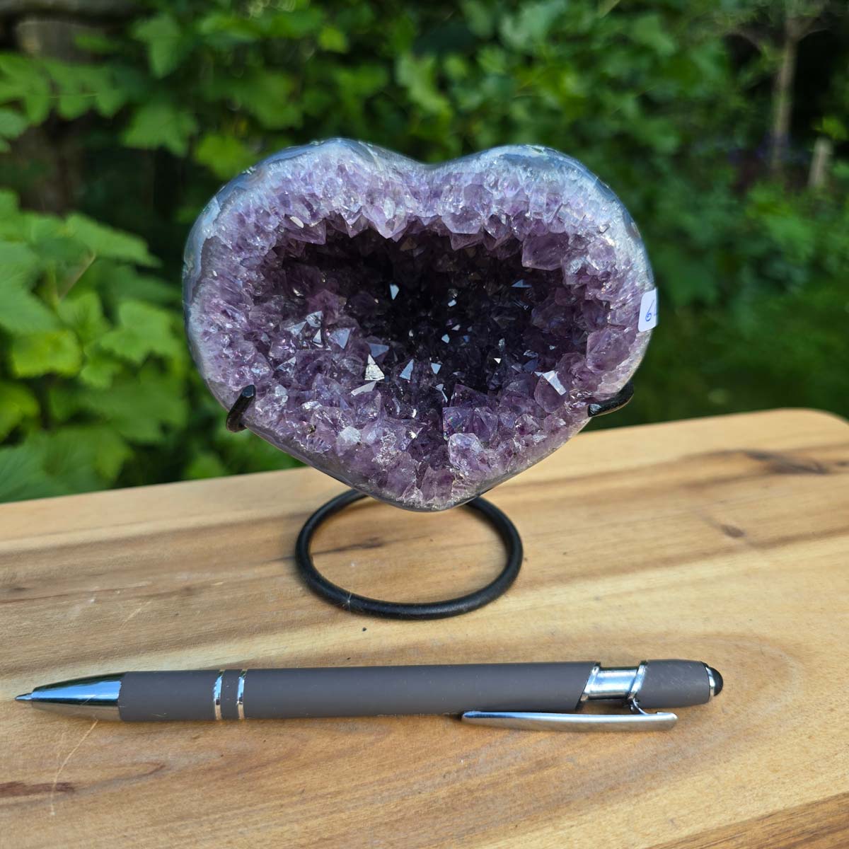 Amethyst Druse Amethyst Geode in Herzform mit Metallsockel 11x10x9cm - NR-60 auf Holzstand, Blick auf Kristallstruktur.