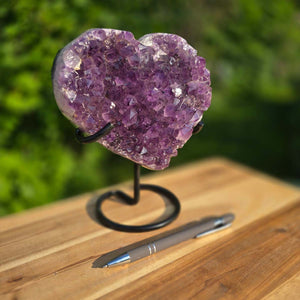 Amethyst Druse Amethyst Geode in Herzform mit Metallsockel 19x16x10cm - NR-63 auf Holzoberfläche mit Stift
