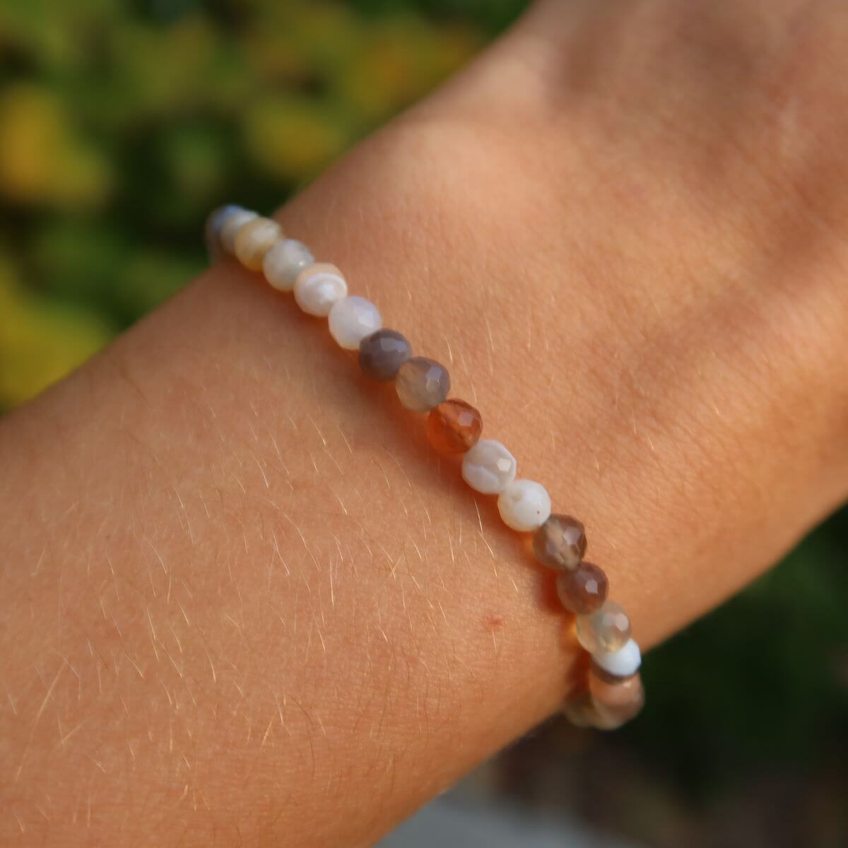 Faceted agate gemstone bracelet in various colors on wrist, showcasing unique patterns and vibrant shades, 4-6-8mm beads.