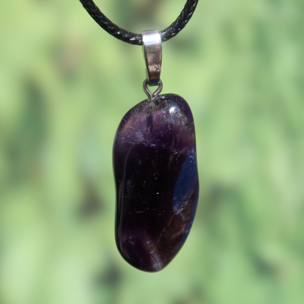 Amethyst Anhänger mit Silberöse - Schutz und Spiritualität - UNIKAT Nr. 16 in violettem Glanz auf grünem Hintergrund.