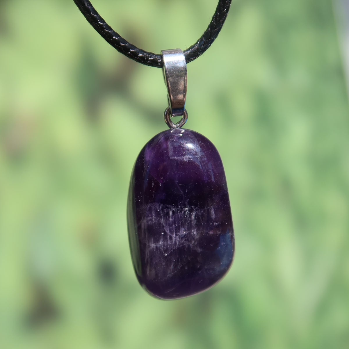 Amethyst Anhänger mit Silberöse - Schutz und Spiritualität - UNIKAT Nr. 17 vor grünem Hintergrund