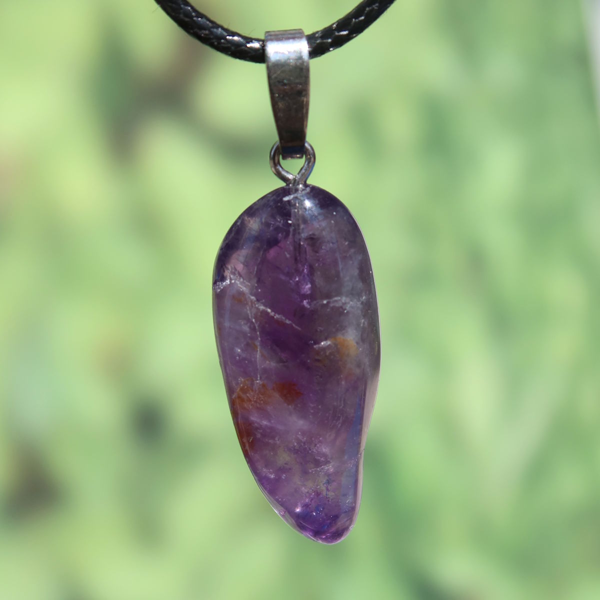 Amethyst Anhänger mit Silberöse - Schutz und Spiritualität - UNIKAT Nr. 19, violetter Edelstein mit Silberöse auf grünem Hintergrund