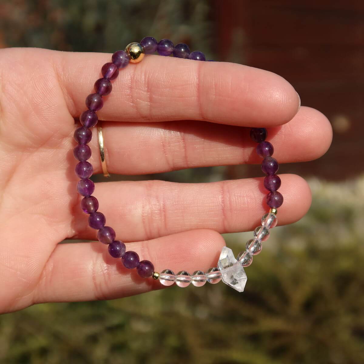 Handcrafted amethyst, quartz, and Herkimer diamond gemstone bracelet on wrist, 17cm, showcasing elegant design and natural stones.