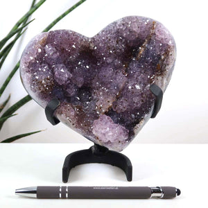 Amethyst Druse Amethyst Geode in Herzform mit Metallsockel 14x12cm - NR-10 auf schwarzem Ständer, mit funkelnden Kristallen.