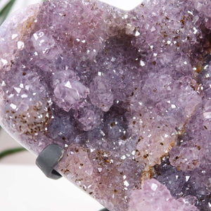 Nahaufnahme von Amethyst Druse Amethyst Geode in Herzform mit Metallsockel 14x12cm - NR-10, funkelnde violette Kristalle.