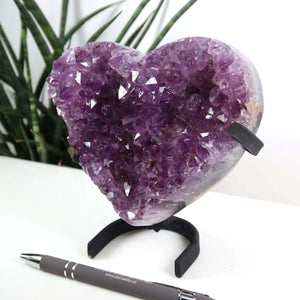 Amethyst Druse Amethyst Geode in Herzform mit Metallsockel 14x12cm - NR-24 auf weißem Hintergrund, präsentiert auf einem Halter