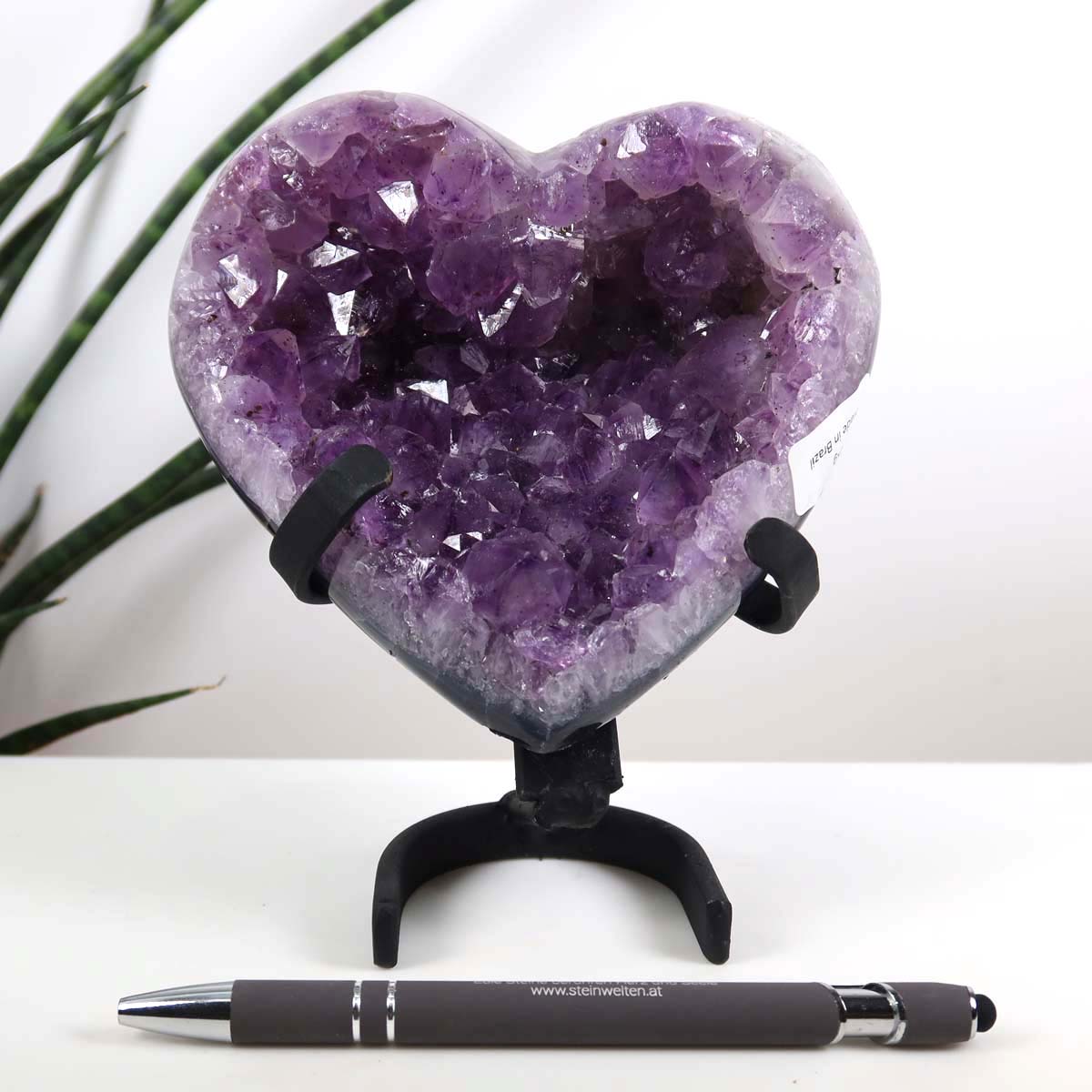 Amethyst Druse Amethyst Geode in Herzform mit Metallsockel 12x12cm - NR-6 auf einem Tisch, daneben ein Stift