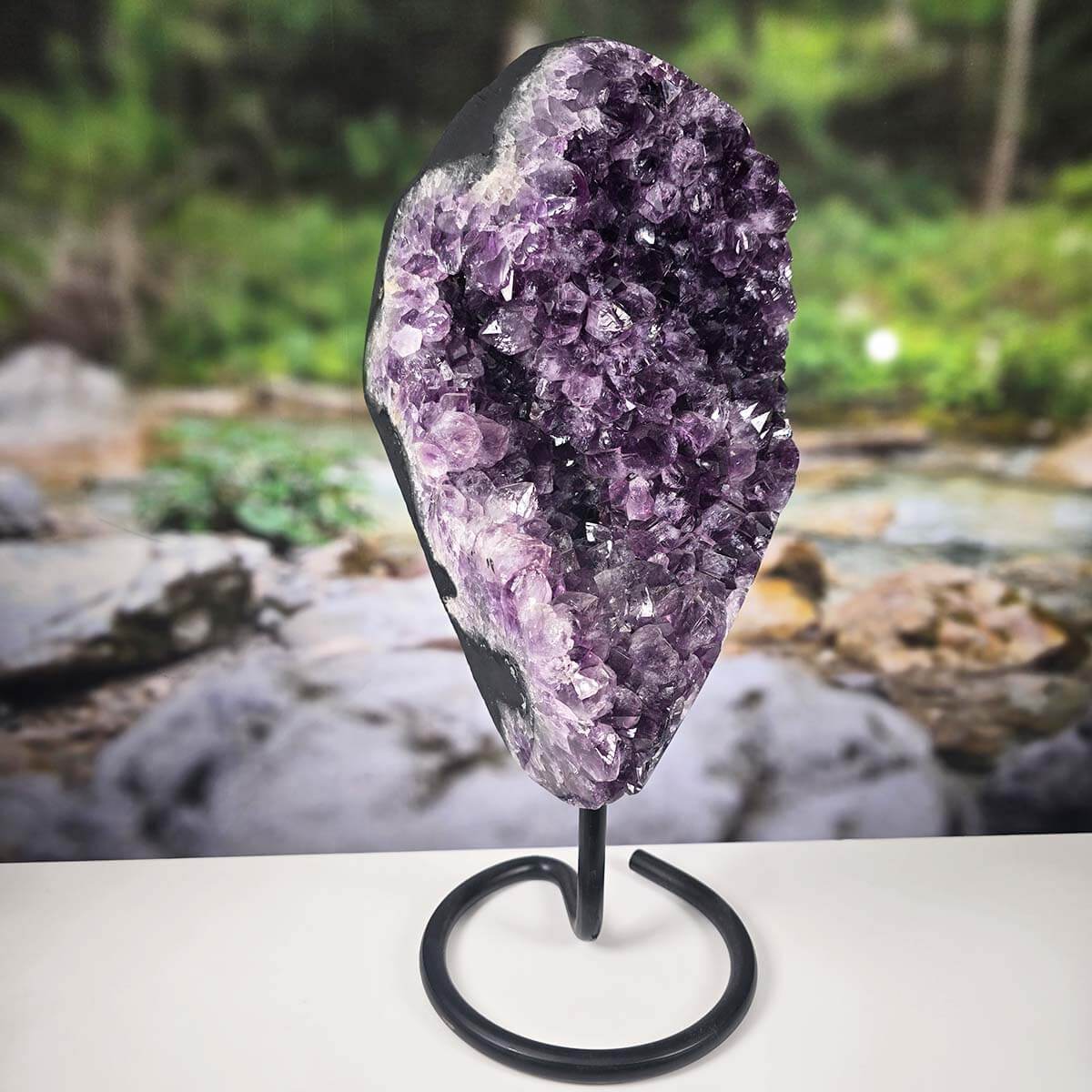Uruguay Amethyst Drusen Geode on metal stand, showcasing deep purple crystals and intense sparkle against a natural background.