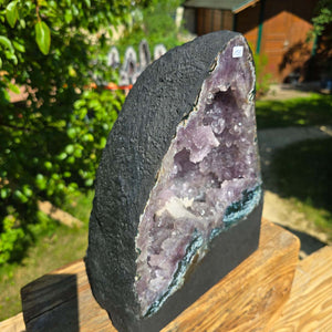 Amethyst Druse – Geode - 29x23x18cm und 13kg – Steinwelten OG - Nr. 135 in sunlight highlighting purple crystals outdoors.