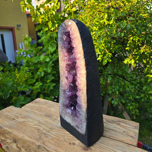 Amethyst Druse – Geode - 51x20x19cm und 22kg – Steinwelten OG - Nr. 218 in an outdoor setting, showcasing its unique crystal structure.