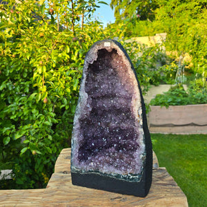 Amethyst Druse – Geode - 39x22x20cm und 14,4kg – Steinwelten OG - Nr. 220 displayed in a garden setting