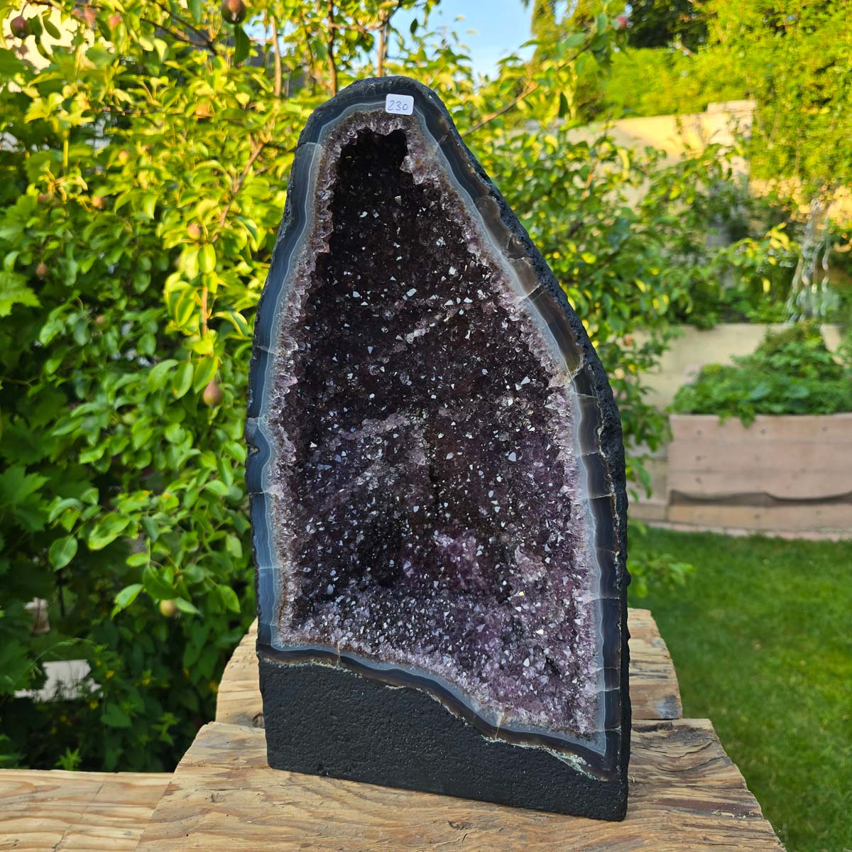 Amethyst Druse – Geode - 42x25x19cm und 17,4kg – Steinwelten OG - Nr. 230 auf Holztisch im Garten