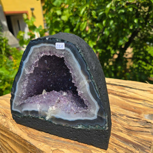 Amethyst Druse – Geode - 16x18x13cm und 4,2kg – Steinwelten OG - Nr. 251 on wooden surface with greenery background