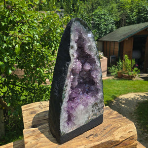 Amethyst Druse – Geode - 35x19x15cm und 10,2kg – Steinwelten OG - Nr. 256 in a garden setting.