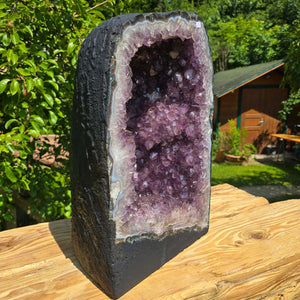 Amethyst Druse – Geode - 44x28x22cm und 32,4kg – Steinwelten OG - Nr. 29 in a natural garden setting.