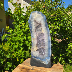 Amethyst Druse – Geode - 48x19cm und 16,6kg – Steinwelten OG - Nr. 308 with vibrant crystals from Brazil on display outdoors.