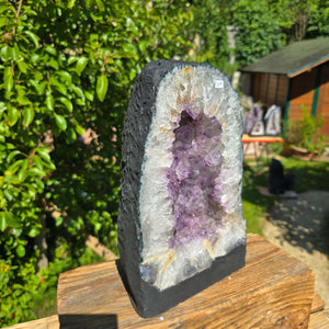 Amethyst Druse – Geode - 30x20x13cm und 9,8kg – Steinwelten OG - Nr. 319 in einem Garten auf einem Holzsockel