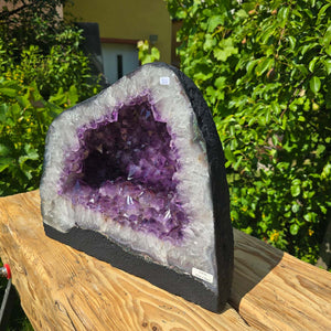 Amethyst Druse – Geode - 32x237x16cm und 22,6kg – Steinwelten OG - Nr. 356 displayed on a wooden surface, vivid purple crystals.