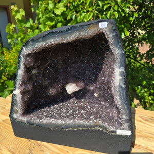 Amethyst Druse – Geode - 31x32x22cm und 19kg – Steinwelten OG - Nr. 358 featured on a wooden table outdoors.