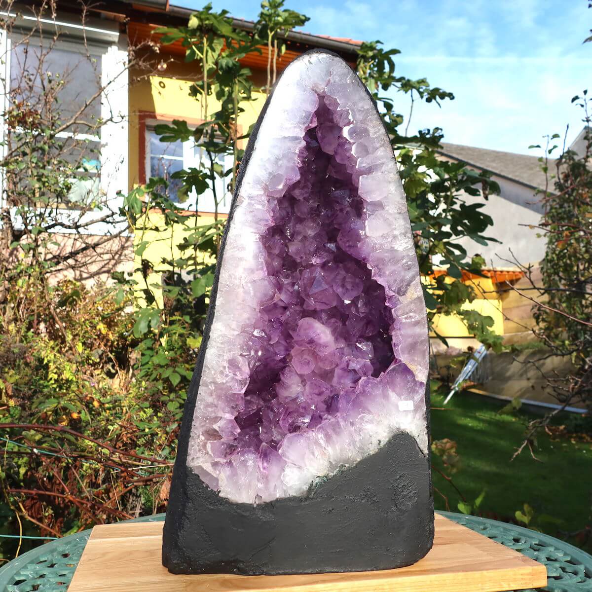 Unique dark AA quality Amethyst geode displayed outdoors, showcasing natural purple crystals for meditation and home decor.