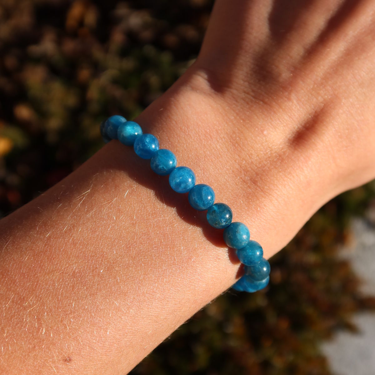 Händetragenes Apatit 1A Edelstein Armband - 1 Stück - in Varianten 4-6-8 oder 10mm, zeigt die strahlende blaue Farbe der Perlen.