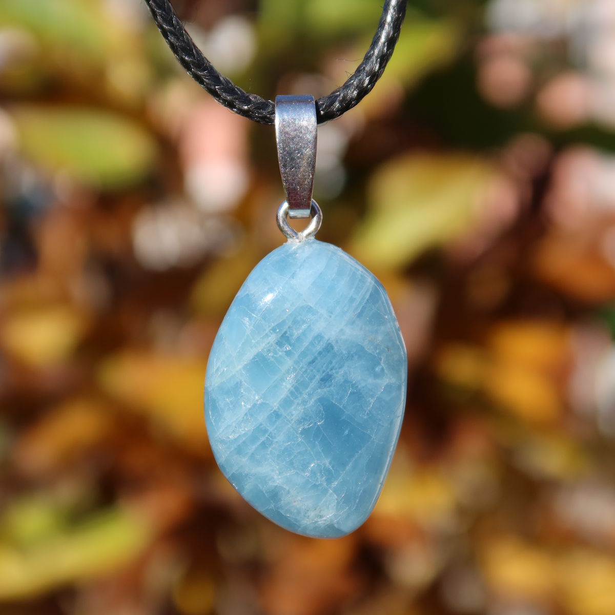 1A Qualität Aquamarin Anhänger 28mm - Ausgeglichenheit und frische Energie - UNIKAT Nr. 3, zarter hellblauer Edelstein vor unscharfem Hintergrund