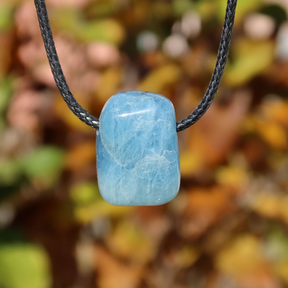 1A Qualität Aquamarin gebohrt 25mm - Ausgeglichenheit und frische Energie - UNIKAT Nr. 14 Anhänger vor buntem Hintergrund