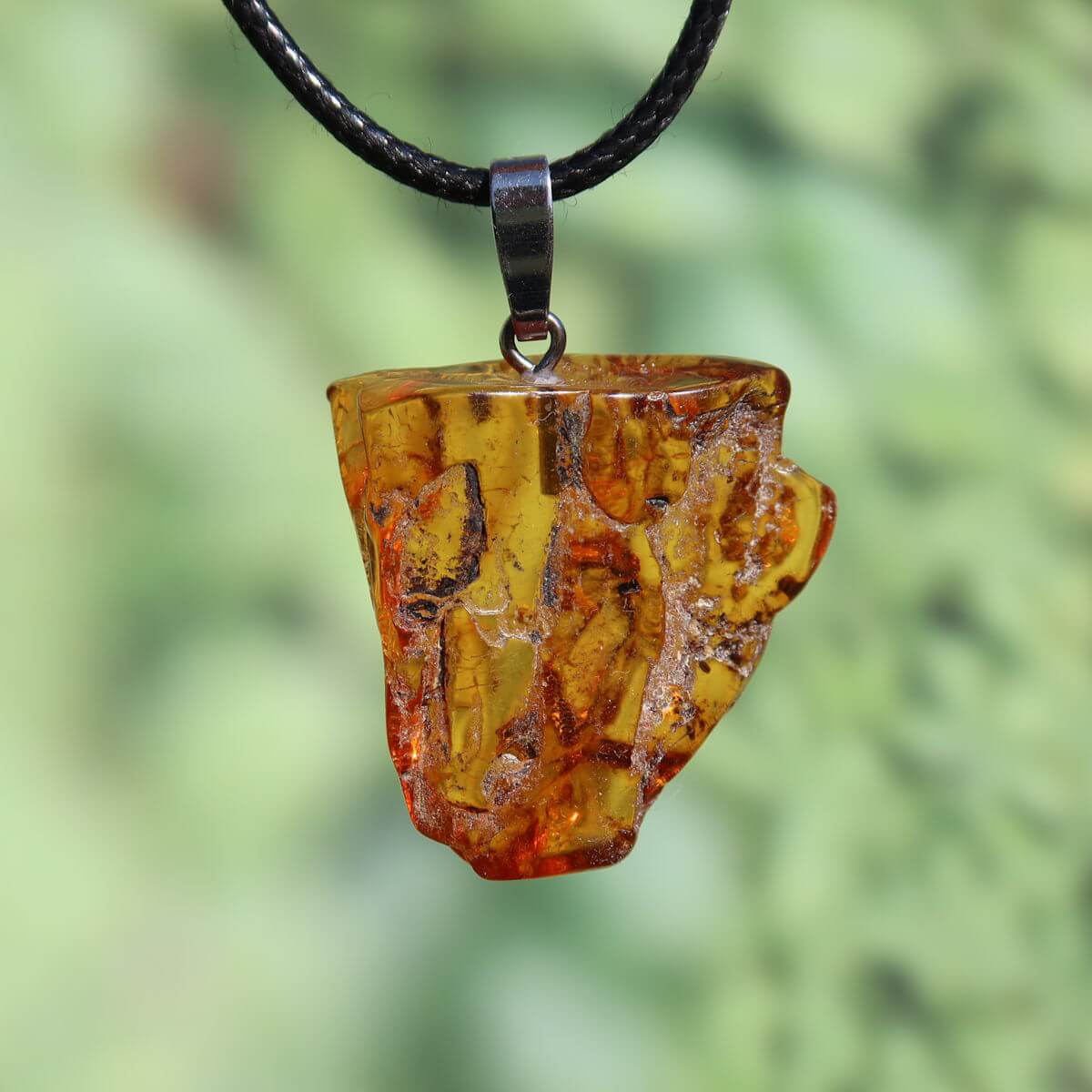 Natürlicher Bernstein Anhänger 31mm mit einzigartiger Struktur, schimmert im Licht, symbolisiert Lebensfreude und Selbstwert.