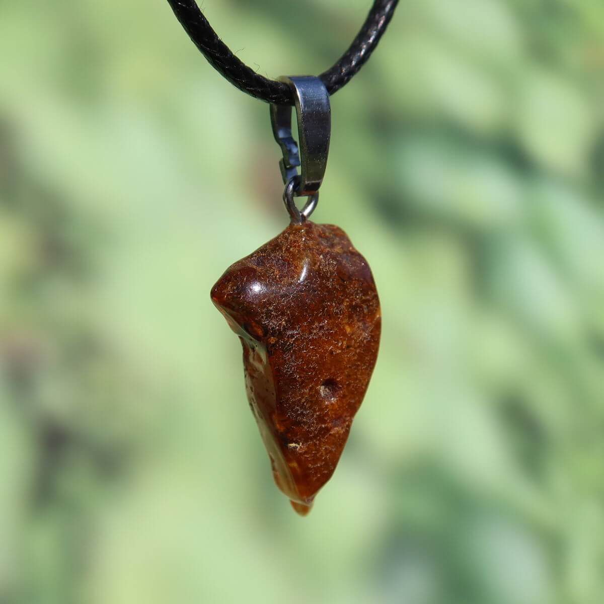 Natürlicher Bernstein Anhänger 30mm vor grünem Hintergrund, einzigartiges Schmuckstück aus pflanzlichem Harz, UNIKAT Nr. 24.