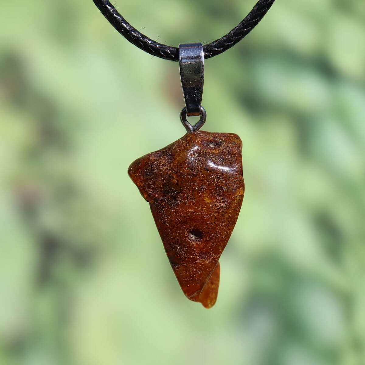 Natürlicher Bernstein Anhänger 30mm vor grünem Hintergrund, einzigartiges Schmuckstück aus pflanzlichem Harz, UNIKAT Nr. 24.