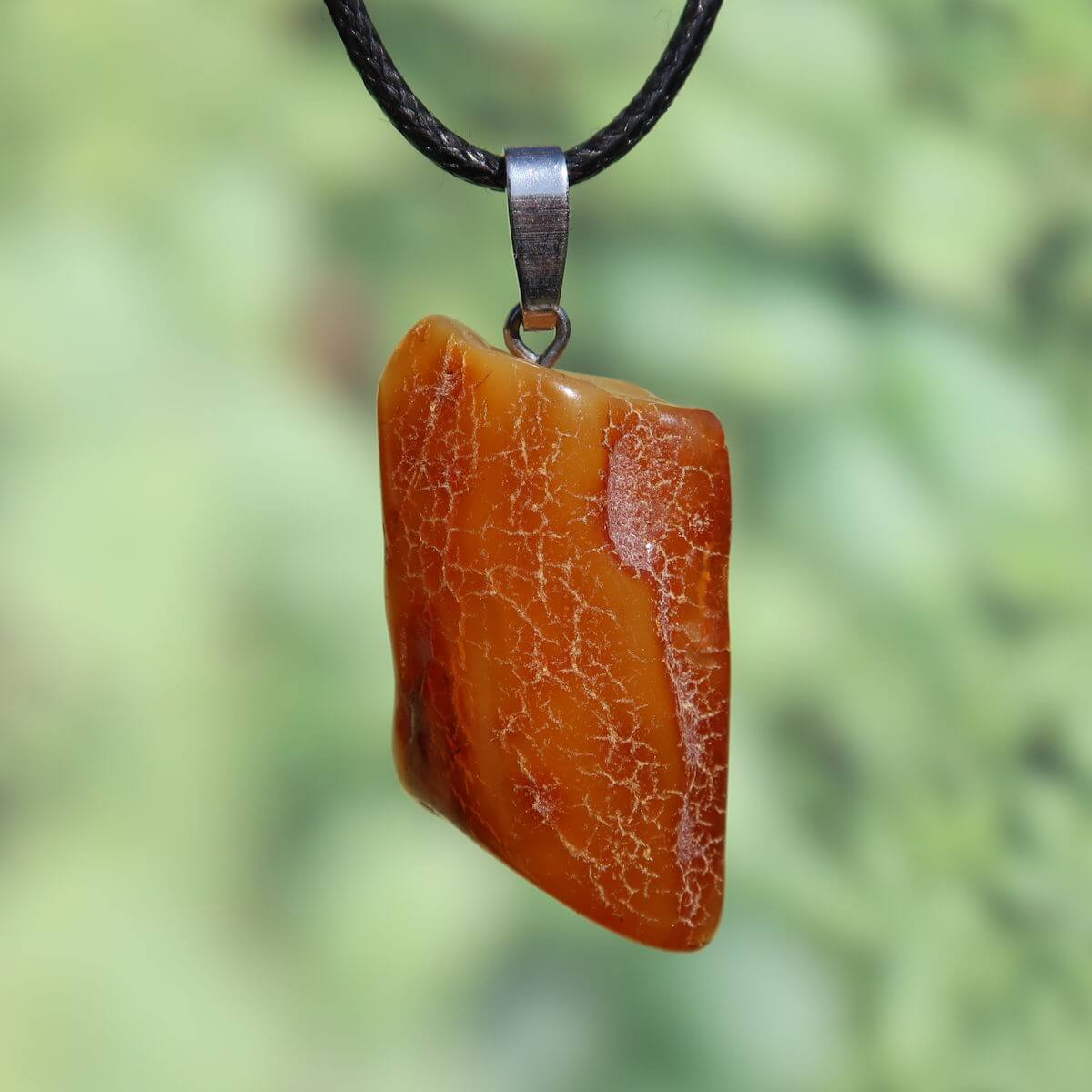 Natürlicher Bernstein Anhänger 40mm, unverwechselbares Unikat mit schimmernder Transparenz vor grünem Hintergrund, Nr. 3.