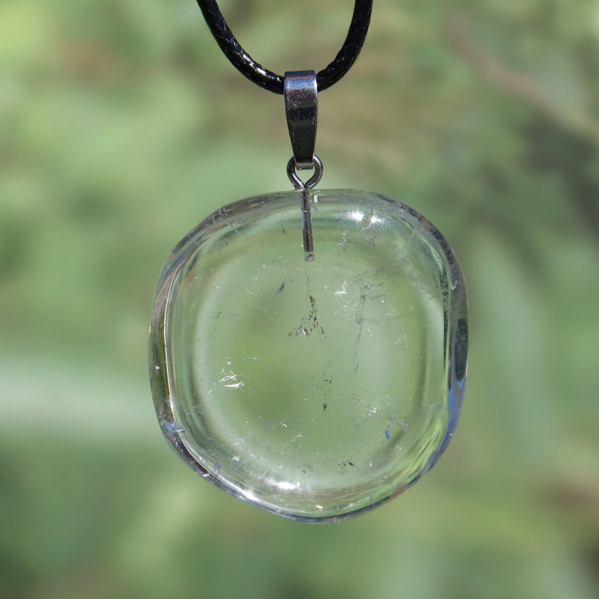 Clear quartz pendant with silver loop, 37mm, promotes clarity and focus, unique piece, nature-inspired background.