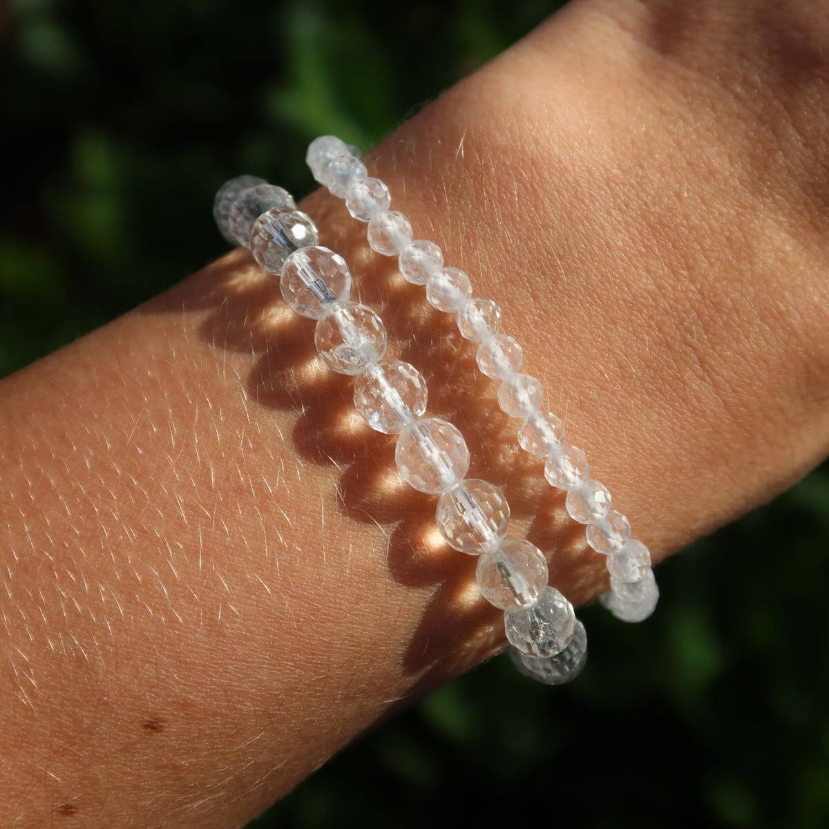 Faceted Bergkristall gemstone bracelet on wrist, featuring clear, sparkling beads in various sizes, 4mm to 8mm.