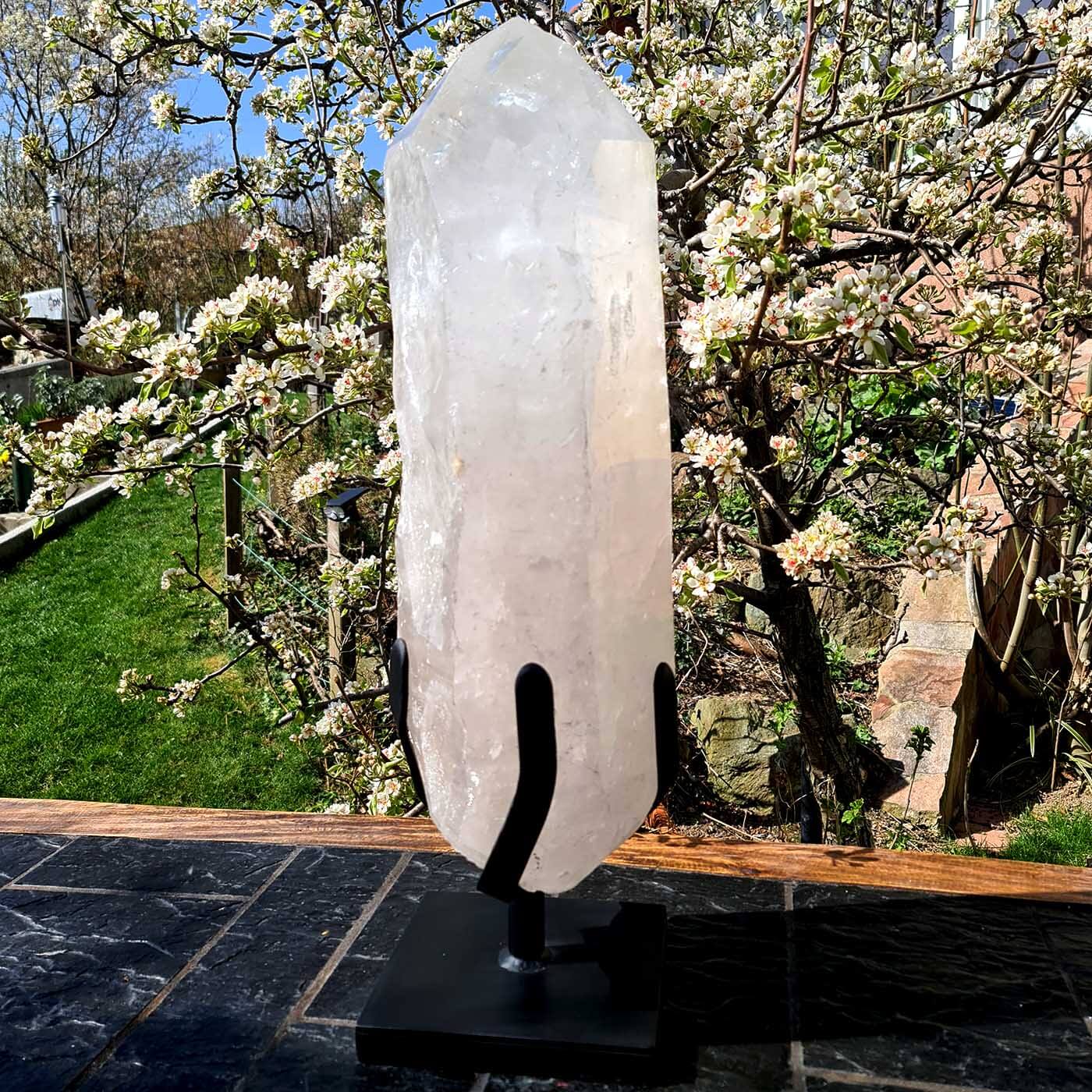 Bergkristall XXL Quarzspitze auf Metallständer im Garten, ideal für Meditationsräume und exklusive Wohnbereiche.