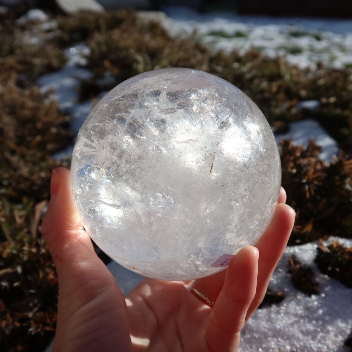 Bergkristall Kugel – Natürliche Kristallkugel 90mm Durchmesser Nr. 27, gehalten in der Hand in natürlichem Licht.