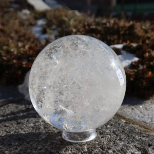 Bergkristall Kugel – Natürliche Kristallkugel 90mm Durchmesser Nr. 27 auf Steinuntergrund in natürlichem Licht