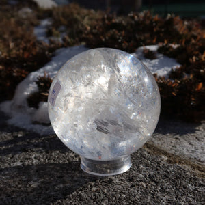 Bergkristall Kugel – Natürliche Kristallkugel 70mm Durchmesser Nr. 29 im Freien auf einem Stein, zeigt ihre natürliche Schönheit