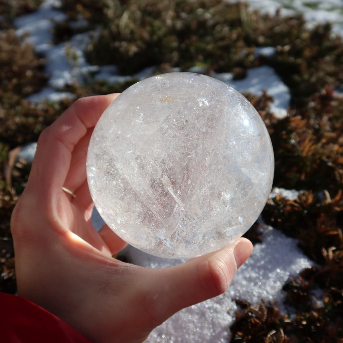 Bergkristall Kugel – Natürliche Kristallkugel 80mm Durchmesser Nr. 30 in Hand gehalten, zeigt Klarheit und natürliche Schönheit.
