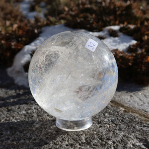 Bergkristall Kugel – Natürliche Kristallkugel 75mm Durchmesser Nr. 32 auf einem Stein im Freien