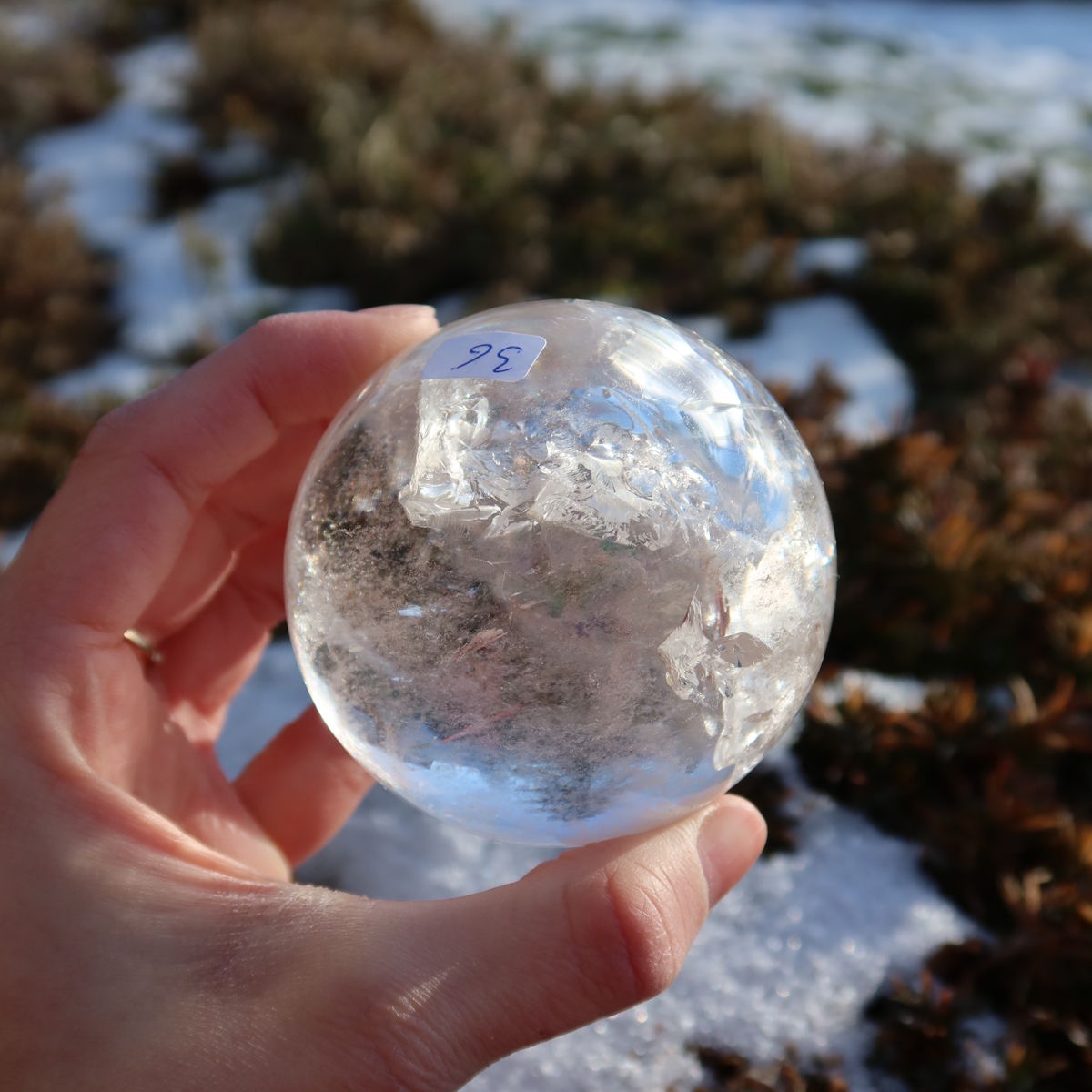 Bergkristall Kugel – Natürliche Kristallkugel 65mm Durchmesser Nr. 36 auf einem felsigen Hintergrund