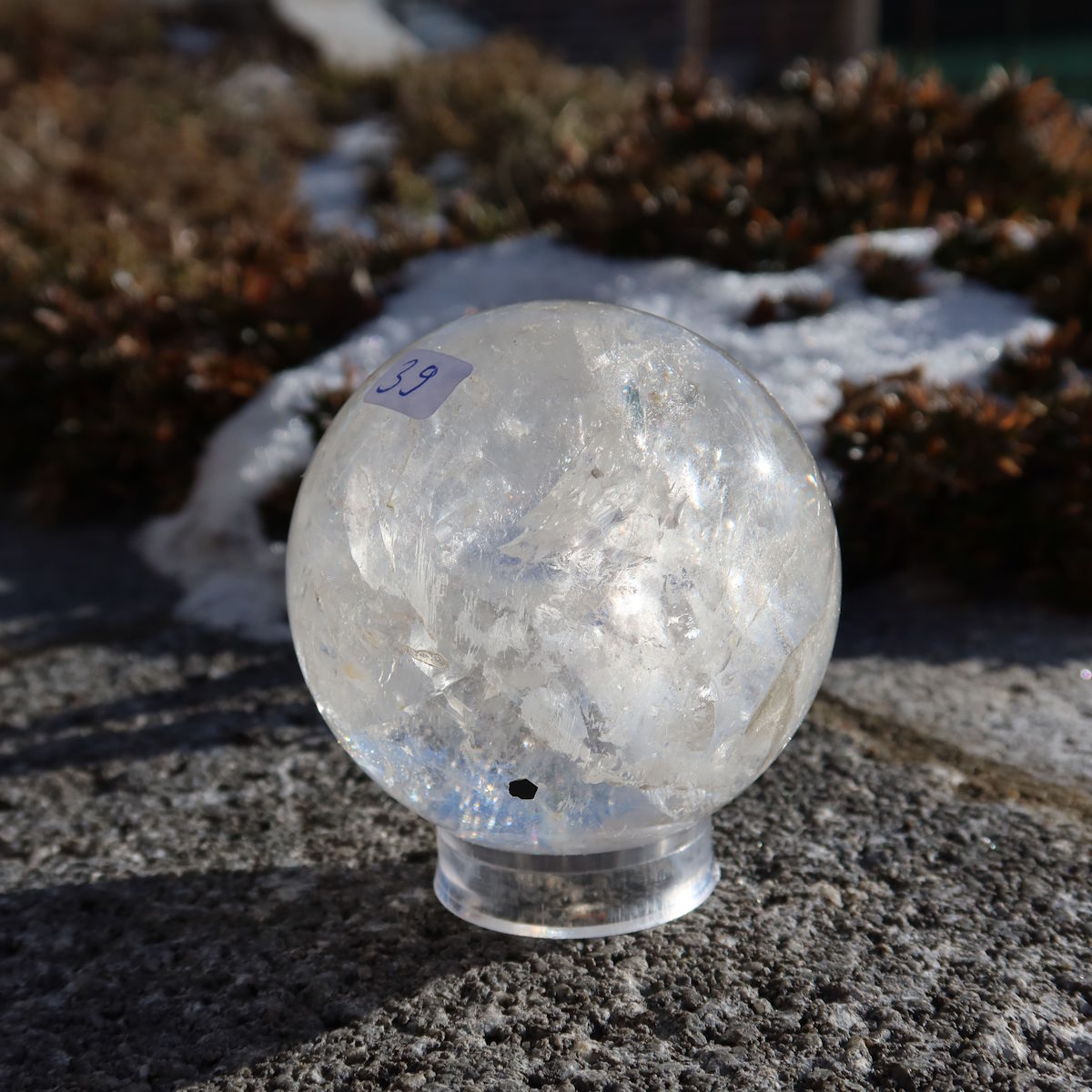Bergkristall Kugel – Natürliche Kristallkugel 60mm Durchmesser Nr. 39 auf Steinunterlage in der Natur