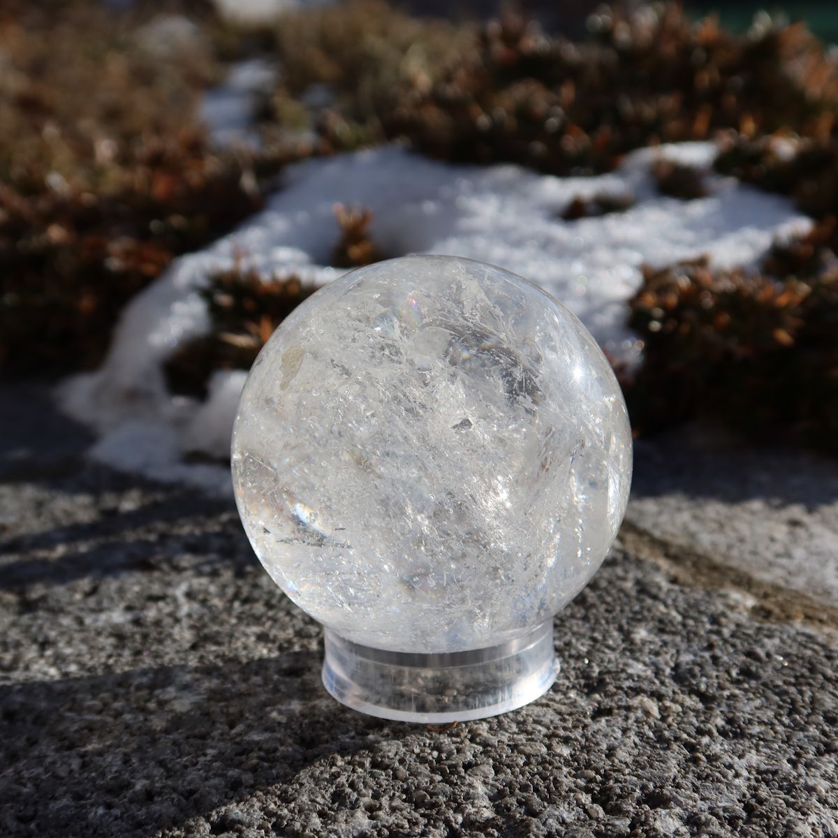 Hand holding Bergkristall Kugel – Natürliche Kristallkugel 55mm Durchmesser Nr. 43 outdoors in sunlight