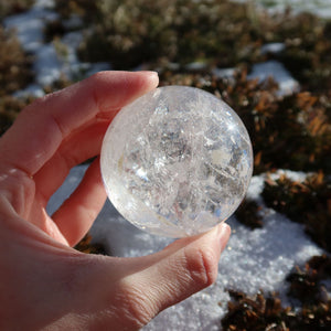 Hand holding Bergkristall Kugel – Natürliche Kristallkugel 55mm Durchmesser Nr. 43 outdoors in sunlight